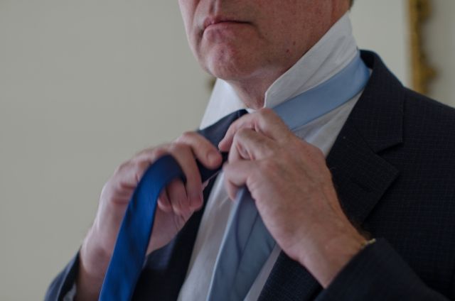 青いネクタイをしめるアメリカ人男性