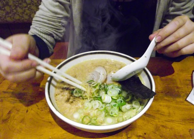 福岡の豚骨ラーメンを食べる人