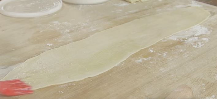 生地を縦に薄く伸ばして溶かしバターを塗る